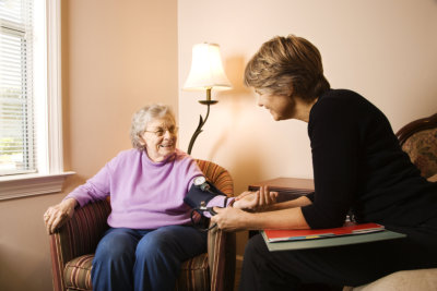 urse checks an elderly woman's blood pressure